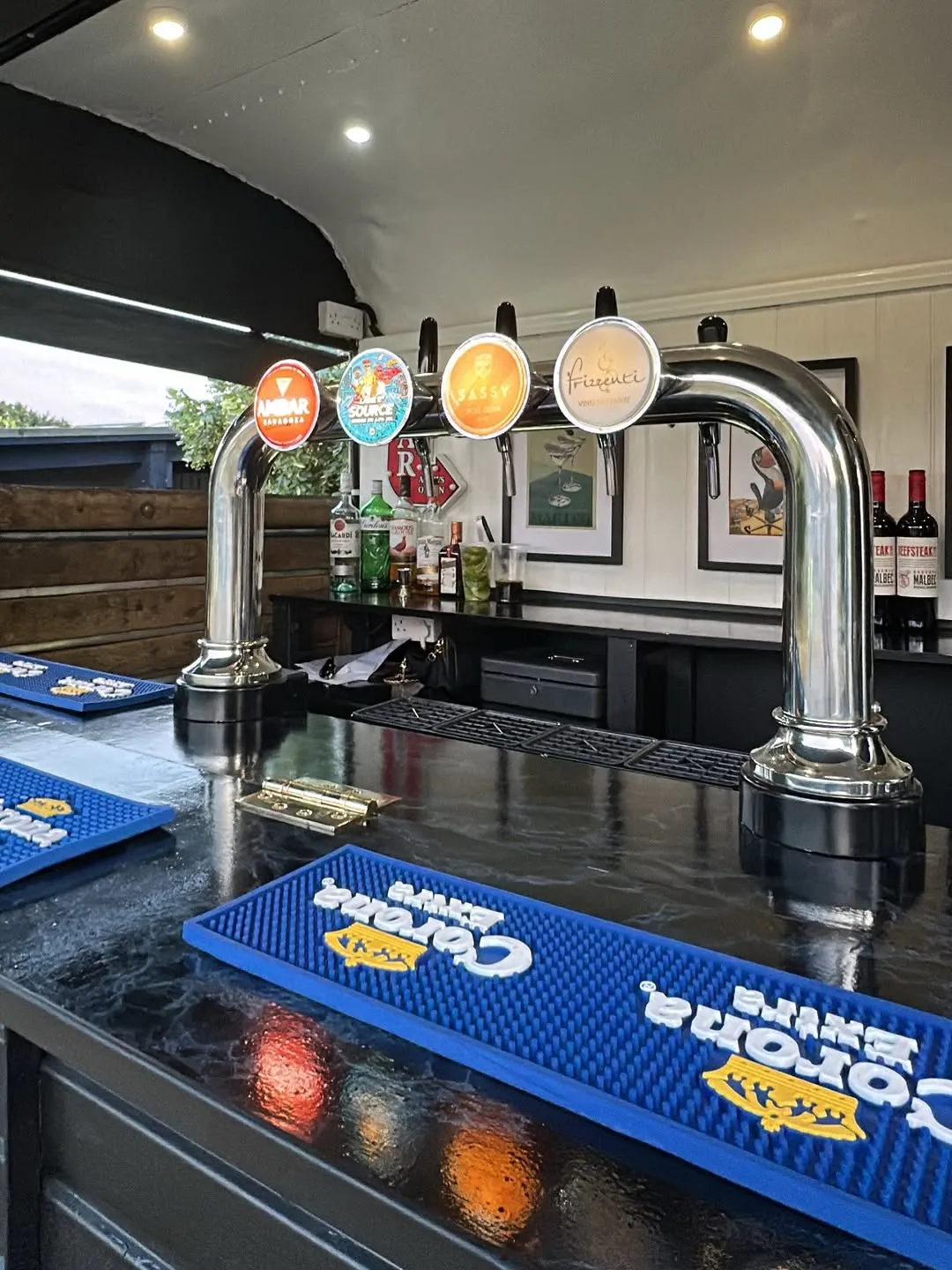 Chrome beer taps and blue bar mats inside the little bars horsebox