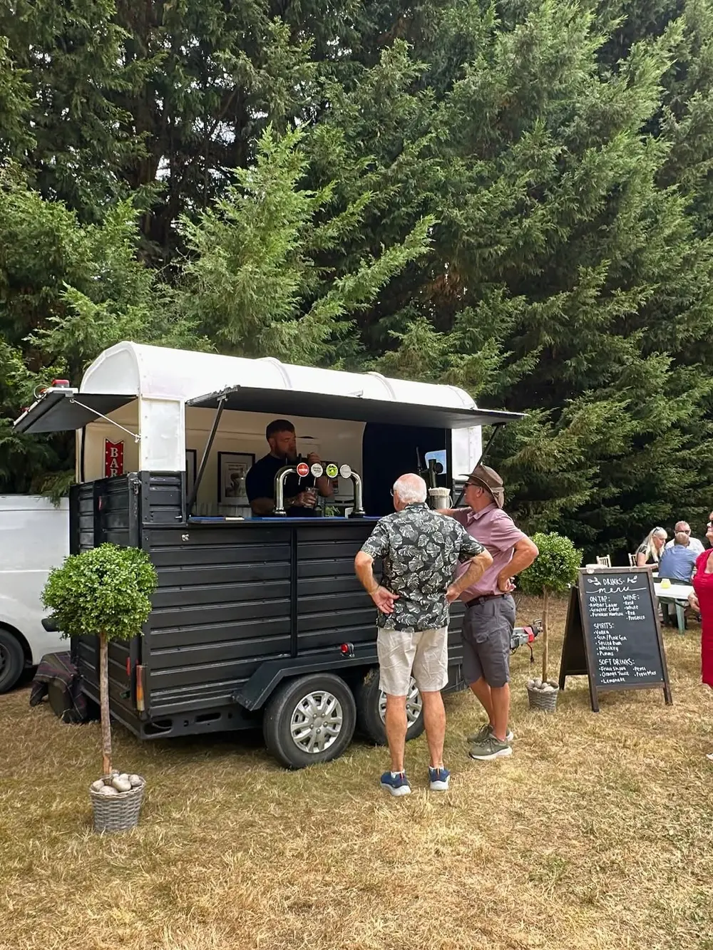 Little bars serving guests from the horsebox at a daytime event